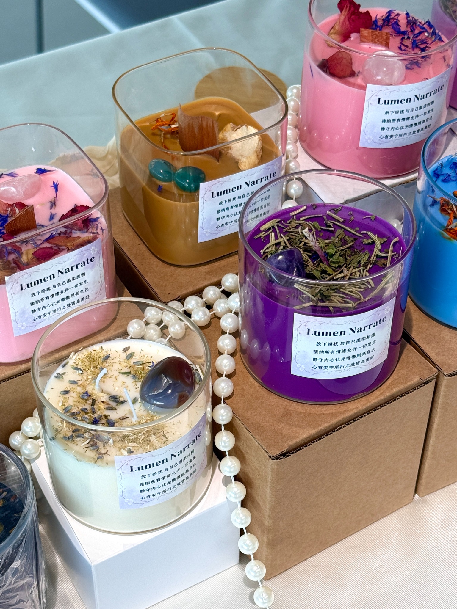 Color-led therapeutic candle collection with botanical and crystal-inspired details