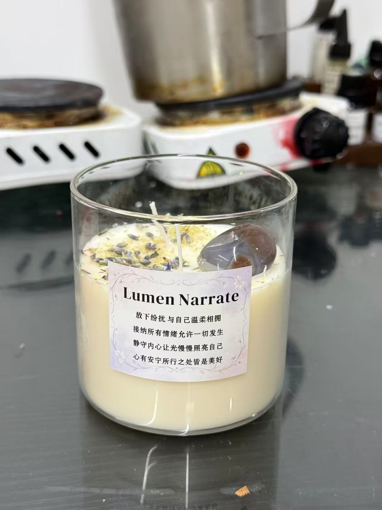 Small batch therapeutic candle sample with botanical and stone details in development setting